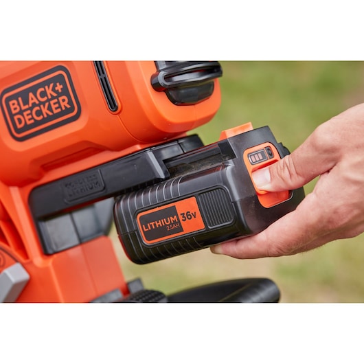Photo of BLACK+DECKER lithium 36V 2.5Ah battery BCBLV3625L1 being inserted into an orange cordless tool.