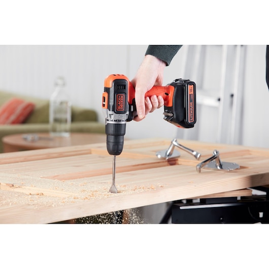 Photo of BLACKDECKER cordless drill BCD003C2K in use drilling into wood indoors.