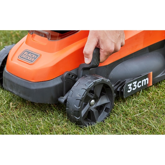 BLACK+DECKER BCMW3336L2 lawn mower close-up on wheel adjustment lever and 33cm cutting width label.