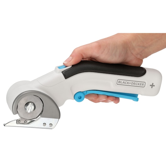 BLACK+DECKER BCRC115 rotary fabric cutter with white and blue handle, side view, held in hand.