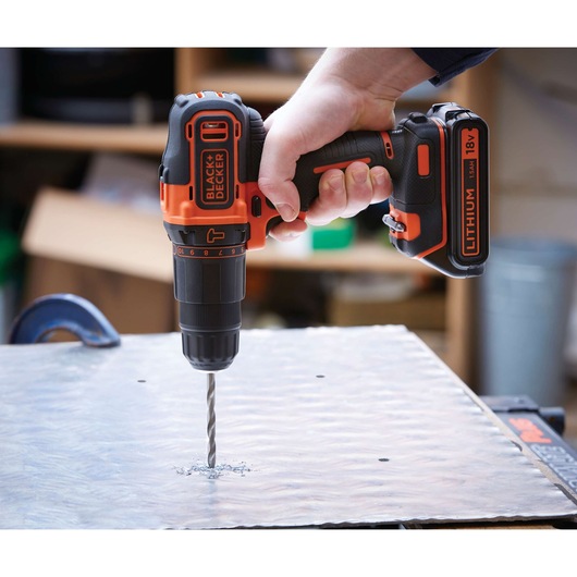 Photo of BLACK+DECKER BDC718AS2F cordless drill with lithium 18V battery drilling metal sheet.