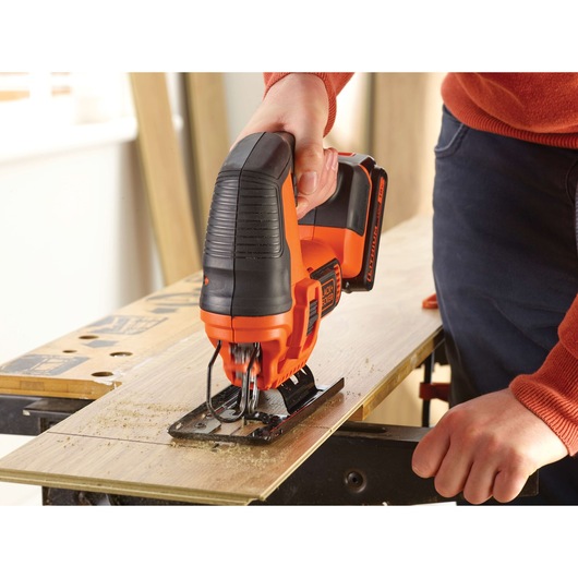 BLACKDECKER BDCJS18N cordless jigsaw cutting wood, close-up showing tool in use.