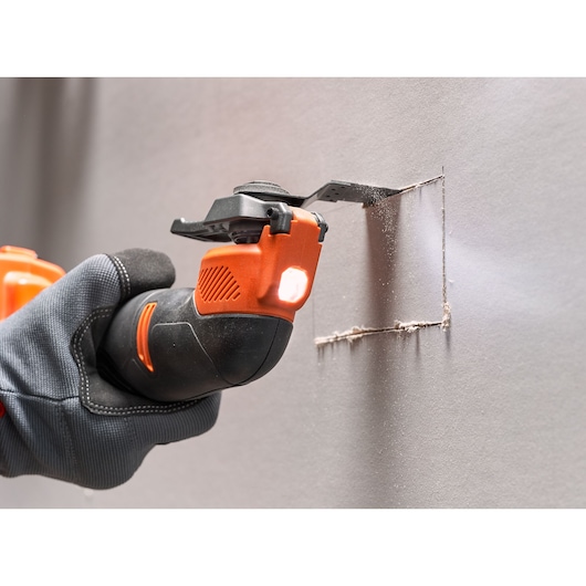 BLACKDECKER BDCOS18N oscillating tool cutting a square in drywall, close-up photography.