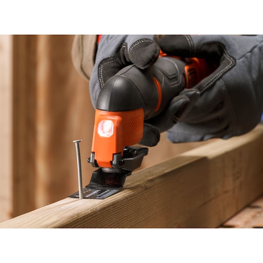 BLACKDECKER BDCOS18N oscillating multi-tool cutting wood near a nail, close-up action shot.