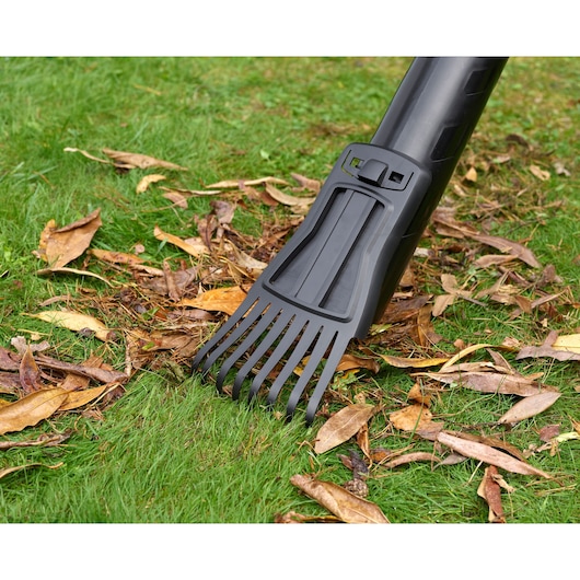 BLACKDECKER BEBLV301 leaf blower tube with rake attachment on grass with dry leaves, close-up angle.
