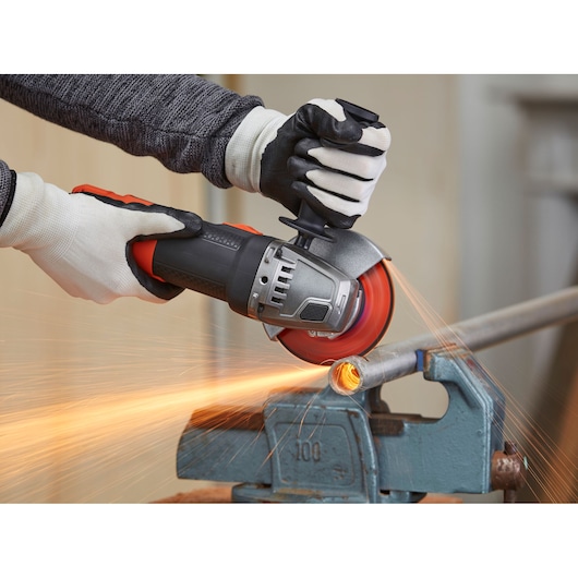 BLACKDECKER BEG210 angle grinder cutting metal pipe, sparks flying, close-up photography.