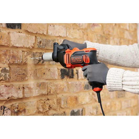 BLACKDECKER BEH850 corded hammer drill used on brick wall, product photography, side angle