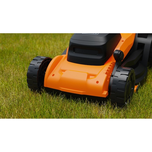 BLACKDECKER BEMWP340-QS lawn mower close-up on grass, showing orange and black front with large wheels.