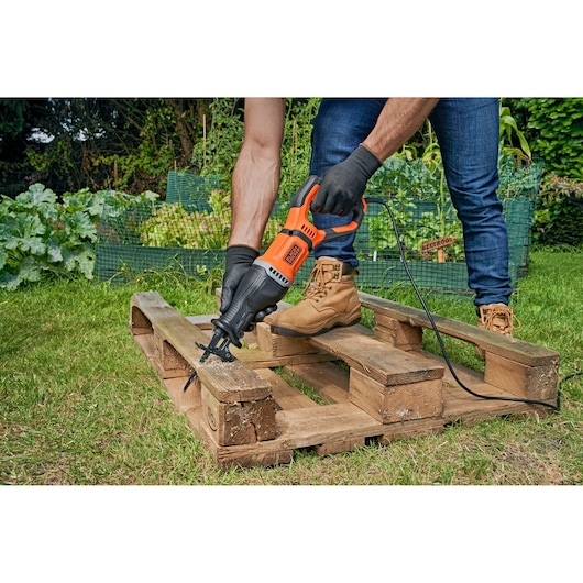BLACKDECKER BES301K reciprocating saw used outdoors to cut wood pallet.