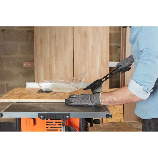 BLACKDECKER BES720 table saw in use, person wearing protective gloves cutting wood panel in workshop.