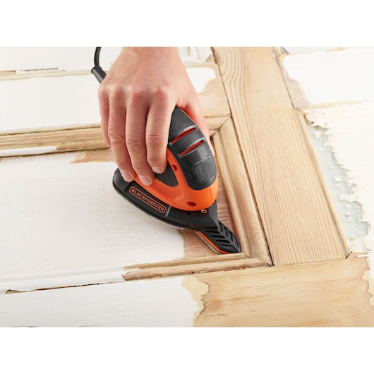 Photo of BLACKDECKER BEW230BCA detail sander in use on a wooden surface, tool held by hand.