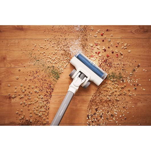 BLACKDECKER BHFEA420J cordless vacuum cleaner cleaning food debris on wooden floor, top view.
