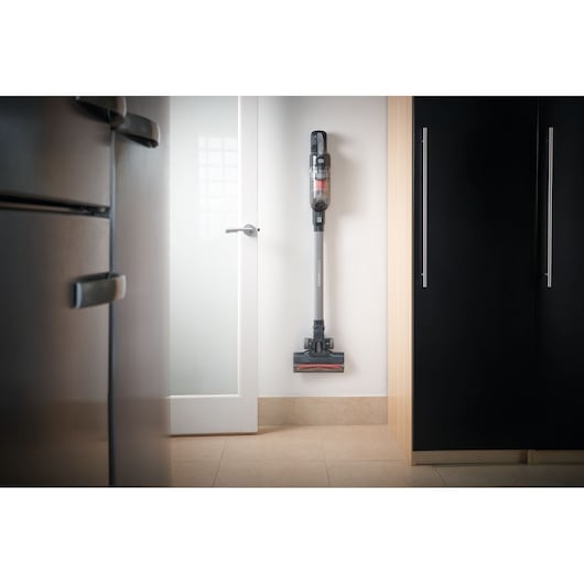 BLACKDECKER cordless stick vacuum BHFEA520J mounted on wall in modern kitchen, front view.