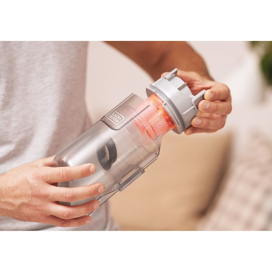 Photo of BLACK+DECKER BHFEA520J vacuum cleaner dust container, close-up of removal mechanism with orange filter.