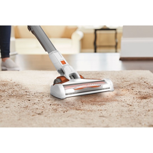 BLACKDECKER BHFEV1825C cordless vacuum cleaner cleaning beige carpet, close-up angle.