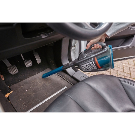 BLACKDECKER BHHV520BF handheld vacuum cleaner with long nozzle used to clean car floor mat.