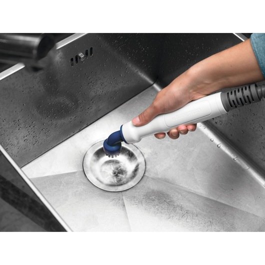 BLACKDECKER BHSM168D cleaning brush used to scrub stainless steel sink drain.