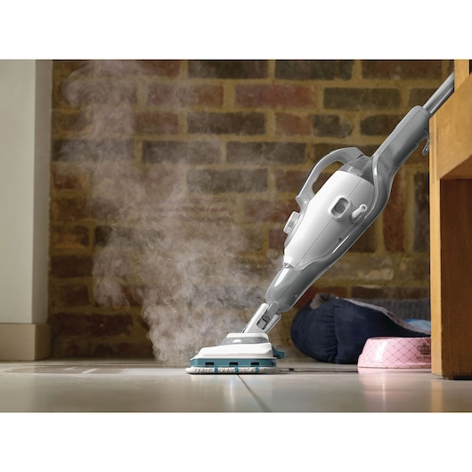 BLACKDECKER BHSM168D steam mop in use on tile floor, releasing steam, shown close-up near pet bowl.