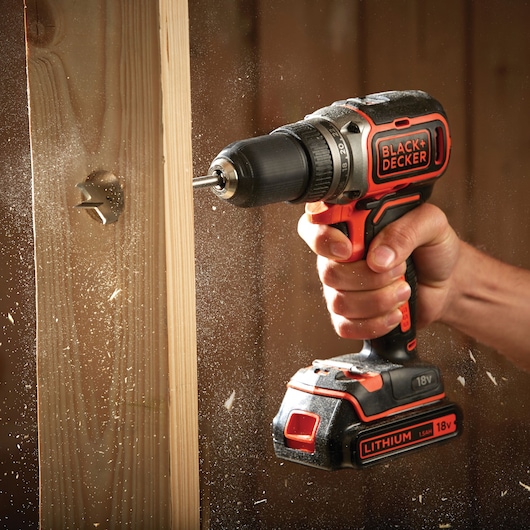 BLACK+DECKER BL186K cordless drill in use drilling into wood, close-up with visible wood shavings.