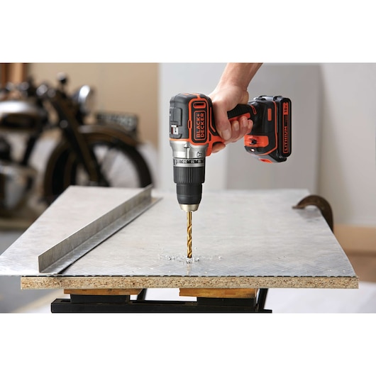 BLACKDECKER BL188K cordless drill in use drilling into a metal sheet, side angle.