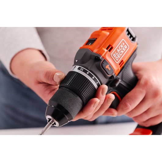 Photo of BLACK+DECKER BLD683D1 cordless drill being adjusted by hand, showing close-up of chuck and torque settings.