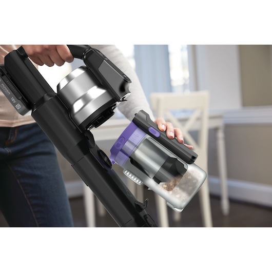 BLACKDECKER BSV520BRP cordless vacuum close-up, showing dust container removal in a modern home setting.