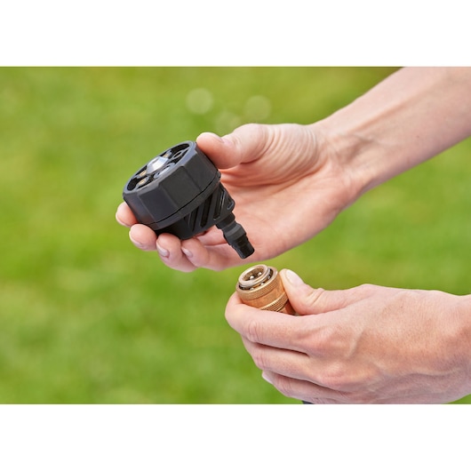 BLACKDECKER BZO51N1 connector part held by hands outdoors, close-up photography.