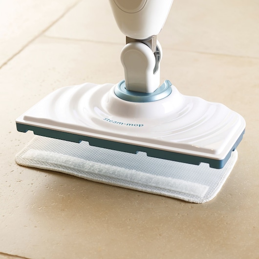 BLACKDECKER FSM1605 steam mop white and blue cleaning head on tile floor, side angle.