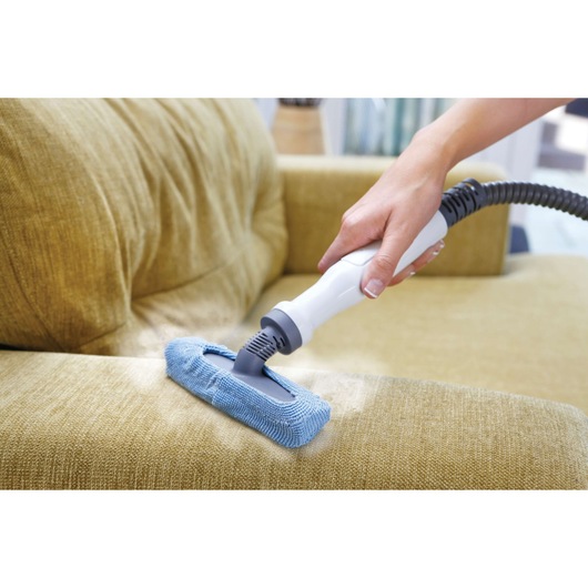 BLACKDECKER FSMH1300FX handheld steam cleaner used on yellow sofa upholstery