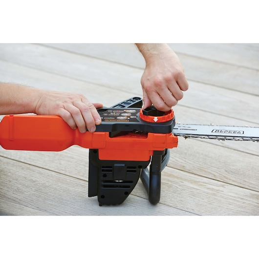 BLACKDECKER GKC1825LB chainsaw photo showing chain adjustment being done on wooden floor.