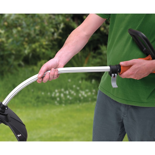 BLACKDECKER GL7033 grass trimmer handle held by person outdoors, orange and black design.