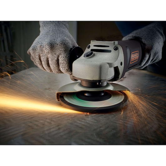 BLACKDECKER KG1202K angle grinder in use, cutting metal with safety gloves, sparks flying.