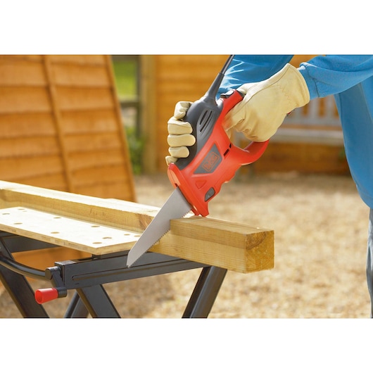 BLACKDECKER KS880EC electric saw with orange and black body cutting wood, side angle.