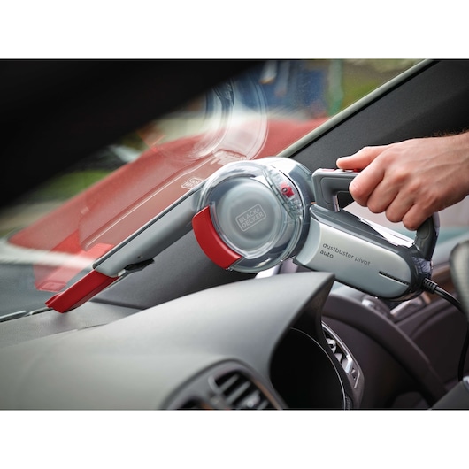 BLACK+DECKER PV1200AV handheld car vacuum cleaner with pivot nozzle in use on car dashboard.