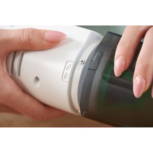 BLACKDECKER REVHV8C handheld vacuum close-up showing dust container removal feature.