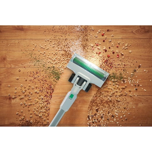BLACKDECKER REVSV18D1 cordless vacuum photographing cleaning cereal and debris from hardwood floor, top view.